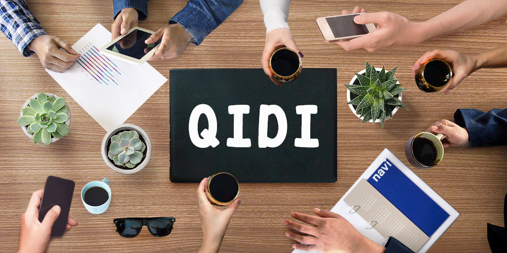People gathered around a table with a QIDI sign